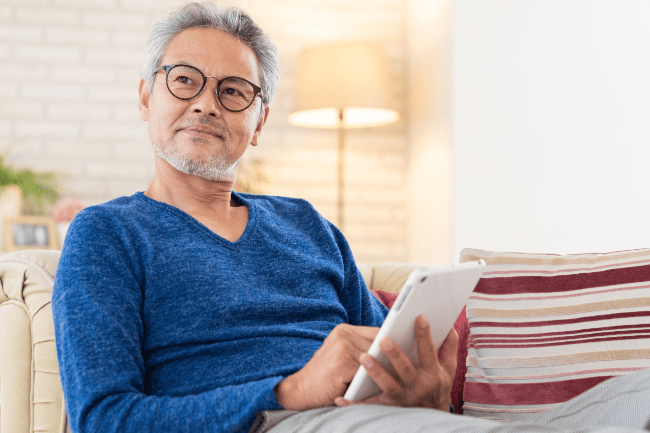 タブレットを持ってソファに座る男性